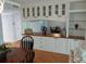 Open dining room with built-in buffet features a decorative mirror, glass cabinets and wood countertop at 3790 Pinebrook Cir # 103, Bradenton, FL 34209