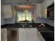 This kitchen has white cabinets, dark countertops, stainless steel appliances, and view to the living area at 3790 Pinebrook Cir # 103, Bradenton, FL 34209