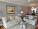 Cozy living room features comfortable couches, a decorative rug, and a unique glass coffee table centerpiece at 3790 Pinebrook Cir # 103, Bradenton, FL 34209