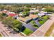 Aerial view of a lovely home with a pool, mature landscaping, and a spacious driveway at 400 Nokomis S Ave, Venice, FL 34285