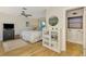 Bedroom featuring light wood floors, a ceiling fan, and a view to an ensuite bathroom at 400 Nokomis S Ave, Venice, FL 34285