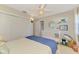 Cozy bedroom with a ceiling fan, a crib, closet and decorative wall shelves at 400 Nokomis S Ave, Venice, FL 34285