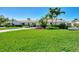 Charming single-story home with lush, green lawn, vibrant tropical landscaping, and a welcoming, circular driveway at 400 Nokomis S Ave, Venice, FL 34285