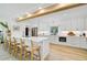 Bright, modern kitchen boasts white cabinetry, stainless appliances, breakfast bar, and hardwood floors at 400 Nokomis S Ave, Venice, FL 34285