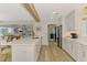 Open-concept kitchen with a large island, wooden beam, and seamless flow to the living area at 400 Nokomis S Ave, Venice, FL 34285