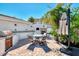 Backyard outdoor kitchen features a pizza oven, stainless grill, and dining area, creating a great space for entertaining at 400 Nokomis S Ave, Venice, FL 34285