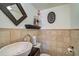 Elegant powder room featuring stone walls, a vessel sink, and decorative accents at 400 Nokomis S Ave, Venice, FL 34285