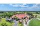 An aerial view of a golf course and clubhouse with gorgeous greens and palm trees at 4002 Las Palmas Way, Sarasota, FL 34238