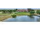 Scenic aerial view highlighting a golf course, a pond, and the clubhouse with manicured lawns at 4002 Las Palmas Way, Sarasota, FL 34238