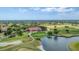 Scenic aerial view capturing the beautifully landscaped golf course, a lake, and luxurious clubhouse at 4002 Las Palmas Way, Sarasota, FL 34238
