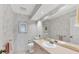 Small bathroom with a sink, toilet, mirror and floral wallpaper at 4002 Las Palmas Way, Sarasota, FL 34238