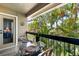 Private balcony area with table and chairs surrounded by tropical foliage at 4009 Crockers Lake Blvd # 25, Sarasota, FL 34238