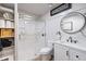 Elegant bathroom with a glass-enclosed shower, modern vanity, and stylish round mirror with storage at 4009 Crockers Lake Blvd # 25, Sarasota, FL 34238