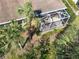 The aerial view shows the screened lanai of the home, plus the surrounding green space and palm trees at 4015 Bridlecrest Ln, Bradenton, FL 34209