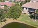 A bird's-eye view of the backyard of the home, with a nice green lawn and a pond beyond the yard at 4015 Bridlecrest Ln, Bradenton, FL 34209