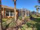Inviting outdoor space with a screened-in patio, offering a relaxing view of the meticulously landscaped backyard at 4015 Bridlecrest Ln, Bradenton, FL 34209