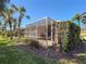 This home's screened patio is nestled amid the tropical beauty of lush palm trees and manicured greenery at 4015 Bridlecrest Ln, Bradenton, FL 34209