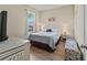 Cozy bedroom with a large window, queen bed, and neutral decor at 4015 Bridlecrest Ln, Bradenton, FL 34209