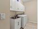 Clean and functional laundry room with white cabinets, stainless steel sink, and modern washer and dryer at 4015 Bridlecrest Ln, Bradenton, FL 34209