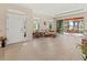 Bright living room featuring tile flooring, large windows, and sliding doors that open to a screened lanai at 4015 Bridlecrest Ln, Bradenton, FL 34209