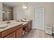 Modern main bathroom featuring dual vanities, wood cabinets, and walk-in shower at 4015 Bridlecrest Ln, Bradenton, FL 34209
