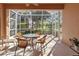 Outdoor screened patio with seating offers scenic views of the lush landscaping and pond at 4015 Bridlecrest Ln, Bradenton, FL 34209