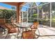 Comfortable screened-in patio featuring an outdoor table with seating and views of the backyard at 4015 Bridlecrest Ln, Bradenton, FL 34209