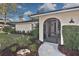 Inviting front entrance features a tiled porch, a screen door, and decorative landscaping at 4099 Southwell Way, Sarasota, FL 34241