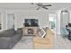 Comfortable living room with modern light gray flooring, entertainment center, fan and neutral-toned sofas at 4099 Southwell Way, Sarasota, FL 34241