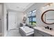 Luxurious bathroom with dual vanities, a soaking tub, and a large window with natural light at 4629 Antrim Dr, Sarasota, FL 34240