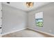 A bedroom with white walls, hard wood floors and a window view of green foliage at 4629 Antrim Dr, Sarasota, FL 34240