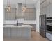 Spacious kitchen with gray cabinets, marble countertops, stainless steel appliances, and a large island at 4629 Antrim Dr, Sarasota, FL 34240