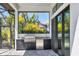 Outdoor kitchen with stainless steel grill and mini fridge, set in a modern patio space surrounded by tropical greenery at 4629 Antrim Dr, Sarasota, FL 34240