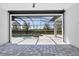 View of a covered pool area with gray tiled deck and a black screen enclosure, creating a private and relaxing backyard oasis at 4629 Antrim Dr, Sarasota, FL 34240