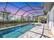 Sparkling screened pool with attached spa, a covered outdoor kitchen, and picturesque landscaping offering serene outdoor living at 4629 Antrim Dr, Sarasota, FL 34240