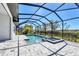 View of a sparkling pool with a built-in spa and paved patio, surrounded by a screened enclosure and lush landscaping at 4629 Antrim Dr, Sarasota, FL 34240