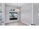 Bright, neutral room with wood floors, modern lighting, and a large window with lush green views at 4629 Antrim Dr, Sarasota, FL 34240