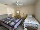 Guest bedroom with ceiling fan, nautical themed quilts, and serene decor at 4933 Village Gardens Dr # 211, Sarasota, FL 34234