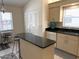 Bright kitchen with island, light cabinetry, and black granite countertops at 4933 Village Gardens Dr # 211, Sarasota, FL 34234