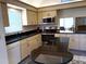 Updated kitchen with granite countertops, stainless steel appliances, and light wood cabinetry at 4933 Village Gardens Dr # 211, Sarasota, FL 34234