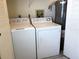 Laundry area including standard washing machine, dryer, and water heater at 4933 Village Gardens Dr # 211, Sarasota, FL 34234