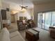 Spacious living room with ceiling fan, cozy furniture and sliding glass doors to the patio at 4933 Village Gardens Dr # 211, Sarasota, FL 34234