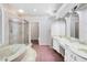 Large bathroom featuring a soaking tub with jets, a glass enclosed shower, and a double sink vanity at 4942 Hidden Oaks Ln, Sarasota, FL 34232