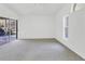 A bright, carpeted bedroom featuring sliding glass doors to the backyard at 4942 Hidden Oaks Ln, Sarasota, FL 34232