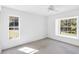 Sunlit bedroom with bright white walls, two windows, and plush carpet at 4942 Hidden Oaks Ln, Sarasota, FL 34232
