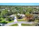 Aerial view of a lovely property featuring mature trees, a side-entry garage, and a well-manicured lawn at 4942 Hidden Oaks Ln, Sarasota, FL 34232