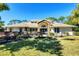 Beautiful home with a manicured lawn, mature flowering bushes, and a grand entrance with double doors at 4942 Hidden Oaks Ln, Sarasota, FL 34232