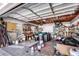 Cluttered garage space, ideal for storage or workshop, featuring open rafters and shelving at 4942 Hidden Oaks Ln, Sarasota, FL 34232