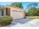 A well-maintained two-car garage provides ample parking and storage space for vehicles and tools at 4942 Hidden Oaks Ln, Sarasota, FL 34232