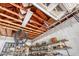 Unfinished garage with exposed rafters and cluttered shelving, offering potential for customization and storage at 4942 Hidden Oaks Ln, Sarasota, FL 34232